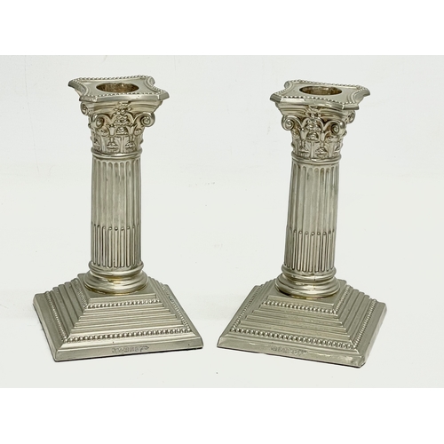 6 - A pair of Walker & Hall silver plated candlesticks with Corinthian style columns. 9x9x17cm