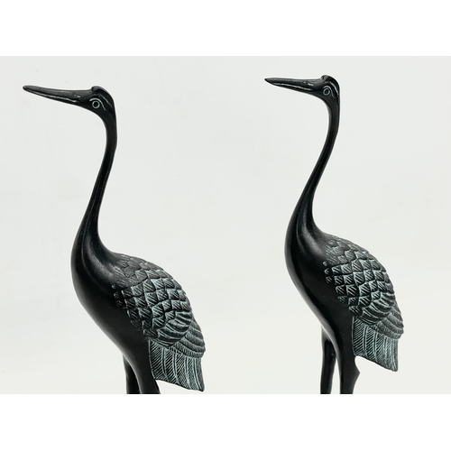 235 - A pair of Chinese bronze cranes on stand. 21x8x27cm