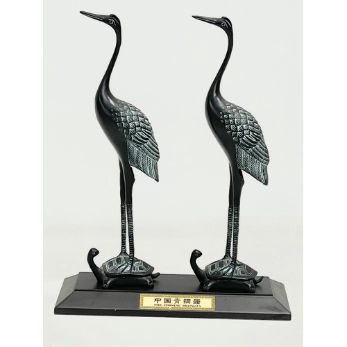 235 - A pair of Chinese bronze cranes on stand. 21x8x27cm