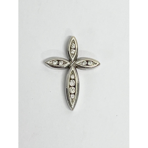 141 - A 9ct white gold and diamond cross pendant. 1.56 grams.