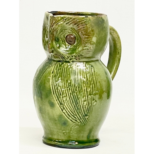 47 - A late 19th century Farnham Pottery green glazed earthenware owl jug. 12x14cm.