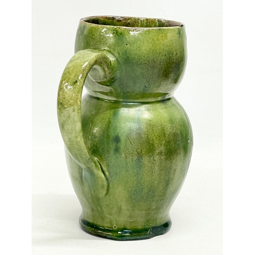 47 - A late 19th century Farnham Pottery green glazed earthenware owl jug. 12x14cm.