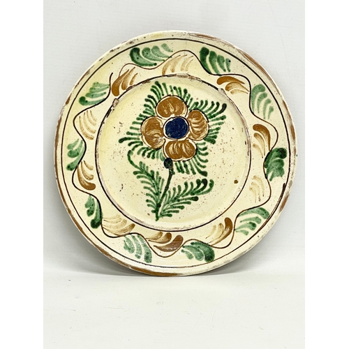 306 - A pair of early 20th century Transylvanian glazed ceramic peasant plates. 24.5cm