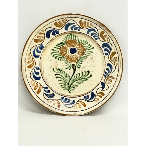 306 - A pair of early 20th century Transylvanian glazed ceramic peasant plates. 24.5cm