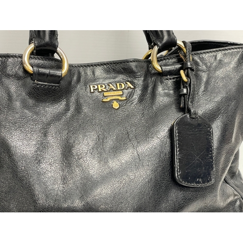 189 - A ladies Prada ‘Vitello’ leather handbag and cover.