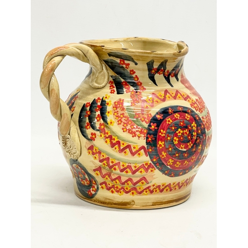 350 - A vintage glazed stoneware jug with twist handle and hand painted decoration. 23x18cm