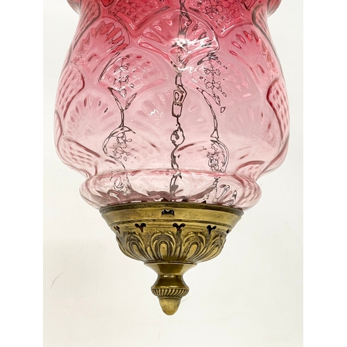 377 - An early 20th century brass and Ruby Glass light shade. Circa 1900. Shade measures 21x34cm. 62cm inc... 