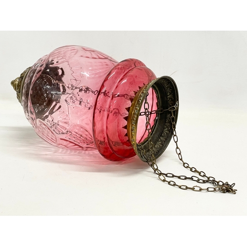 377 - An early 20th century brass and Ruby Glass light shade. Circa 1900. Shade measures 21x34cm. 62cm inc... 