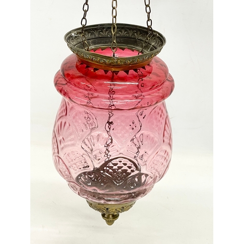 377 - An early 20th century brass and Ruby Glass light shade. Circa 1900. Shade measures 21x34cm. 62cm inc... 