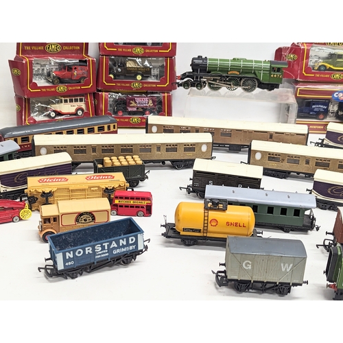 555 - A collection of train carriages including Hornby, with model die-cast toy cars