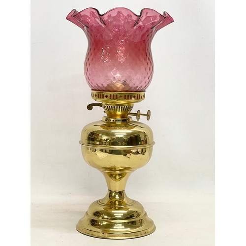 595 - A vintage brass double burner oil lamp with Ruby Glass shade. 42.5cm