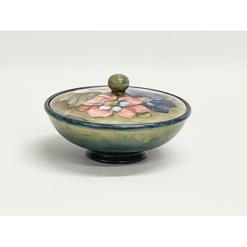 9 - A signed William Moorcroft ‘Clematis’ lidded powder bowl. Pottery to H. M. The Queen. 16x9cm