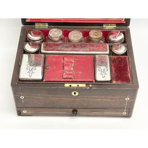 16 - A Victorian rosewood vanity box with Mother of Pearl inlay and cut glass bottles with silver plated ... 