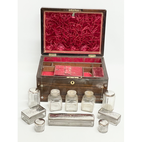 16 - A Victorian rosewood vanity box with Mother of Pearl inlay and cut glass bottles with silver plated ... 