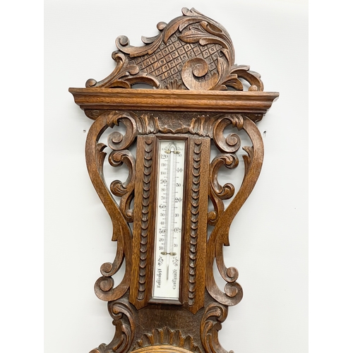 53 - A large Victorian carved oak barometer. 36x98cm