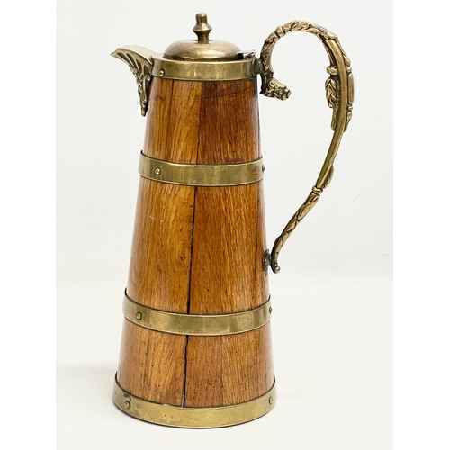 204 - A large late 19th/early 20th century oak brass bound pitcher. Circa 1900. 18x29.5cm