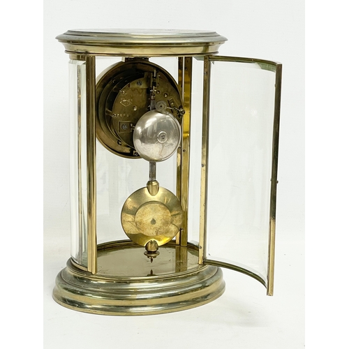 25 - A large late 19th century French oval brass mantle clock with 4 bevelled glass panels and key. Stamp... 