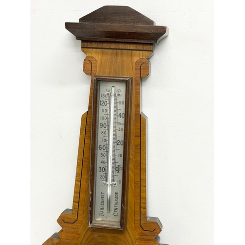 261A - An early 20th century inlaid mahogany barometer. 21x58cm.