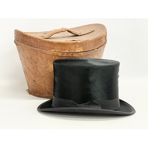 34 - A Victorian leather hat box with a Christie’s of London top hat.