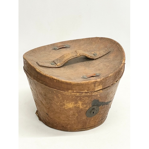 34 - A Victorian leather hat box with a Christie’s of London top hat.