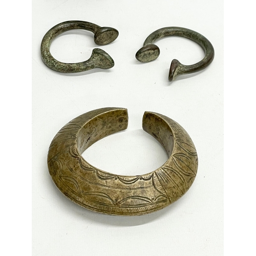 127C - A collection of vintage African heavy brass bangle and bell.