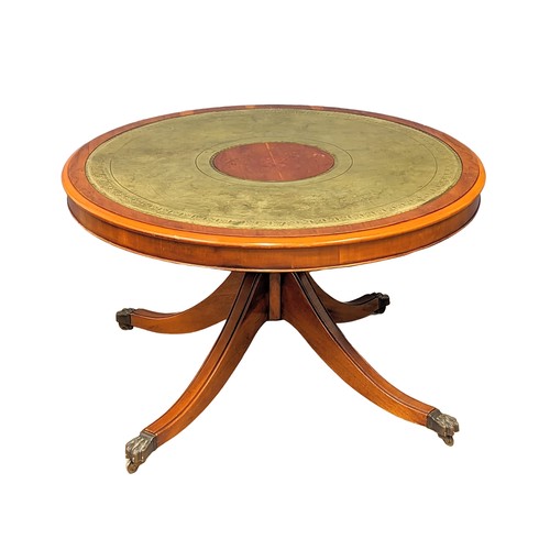 1130 - A Georgian style yew wood drum coffee table with leather top and pedestal base. 90x53cm