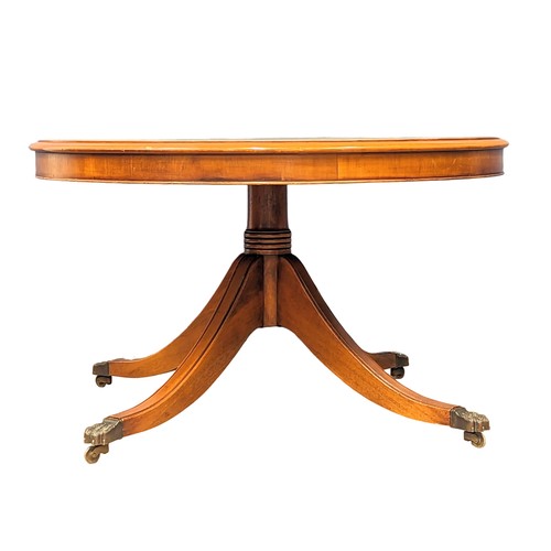 1130 - A Georgian style yew wood drum coffee table with leather top and pedestal base. 90x53cm