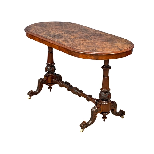 875 - A Victorian Burr Walnut library table with carved cabriole legs and stretcher support. 122x60x72cm