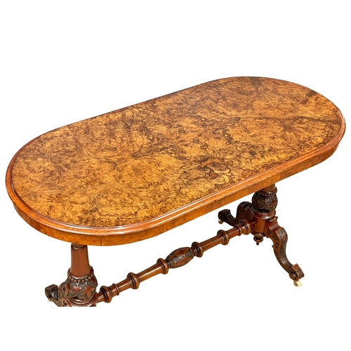 875 - A Victorian Burr Walnut library table with carved cabriole legs and stretcher support. 122x60x72cm