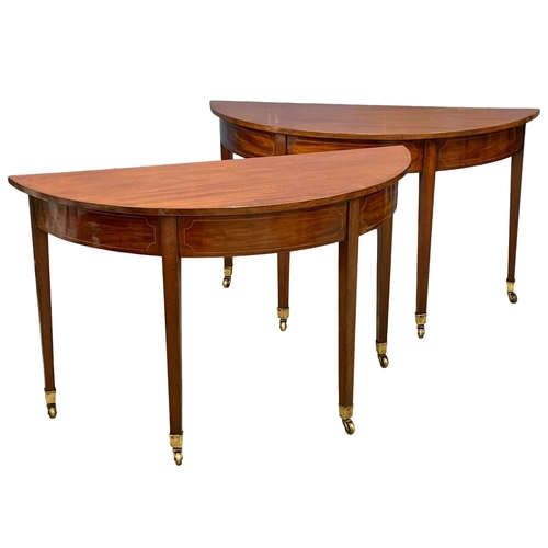 879 - A pair of George III inlaid mahogany D-end console tables on brass cup casters. Circa 1800-1810. 129... 