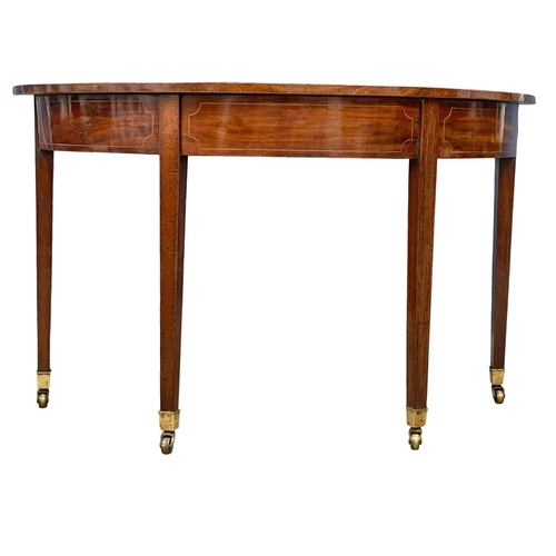 879 - A pair of George III inlaid mahogany D-end console tables on brass cup casters. Circa 1800-1810. 129... 