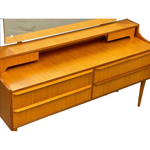 890 - A 1960’s Mid Century teak dressing table. 128.5x40x115.5cm