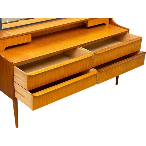 890 - A 1960’s Mid Century teak dressing table. 128.5x40x115.5cm