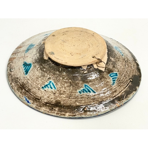 298 - An early to mid 20th century Middle Eastern hand painted terracotta bowl. 26cm