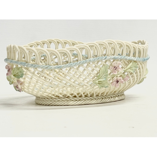 67 - A Belleek Pottery woven basket. 18.5x13.5x6.5cm