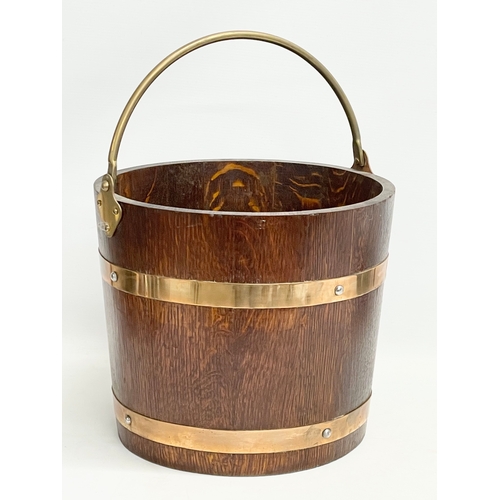 86 - An early 20th century oak brass bound coal bucket by R.A. Lister & Co LTD. Dursley, England. Circa 1... 