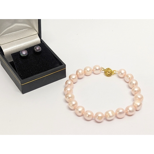 413 - A pair of pearl earrings with a pearl bracelet. Measurements for bracelet open 21.5cmn