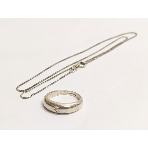 450 - A silver necklace with a silver ring. Chain measures 22cm clasped