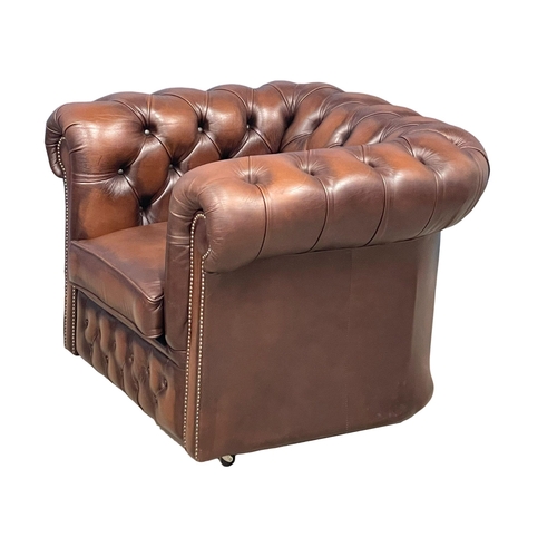 1064 - A deep button leather club armchair. (4)