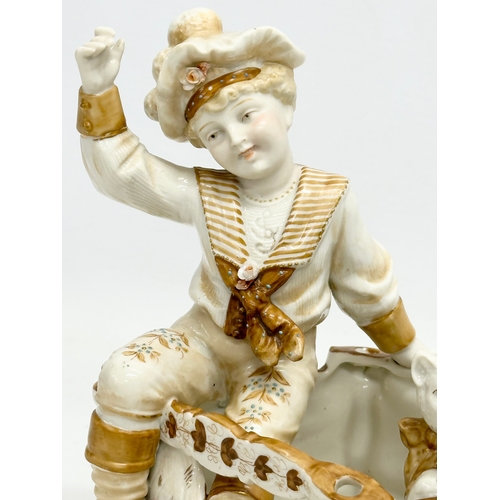 106 - A late 19th century porcelain boy sitting with cat. Makers stamp underneath. 16x12x18cm