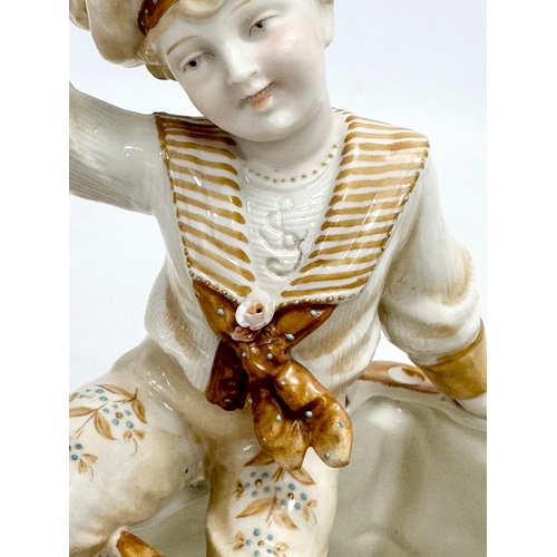 106 - A late 19th century porcelain boy sitting with cat. Makers stamp underneath. 16x12x18cm