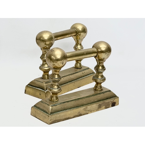 128 - A set of large good quality early 20th century brass fire andirons and tools. 24x41x44cm