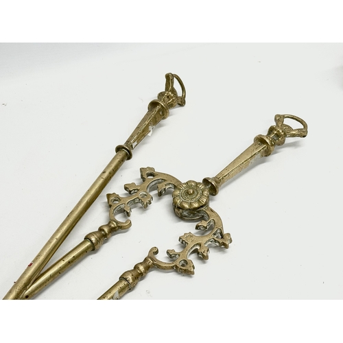 128 - A set of large good quality early 20th century brass fire andirons and tools. 24x41x44cm