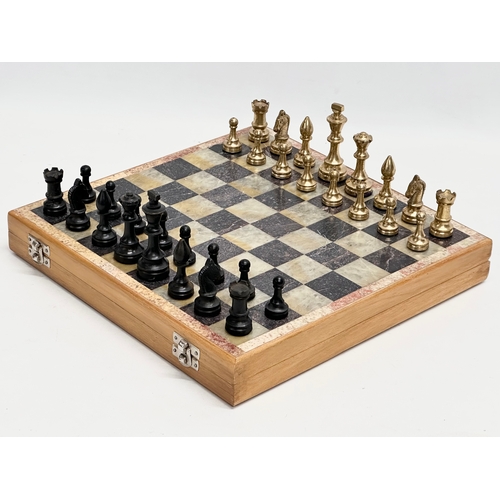 211D - An onyx and brass chess set. 30.5x30cm