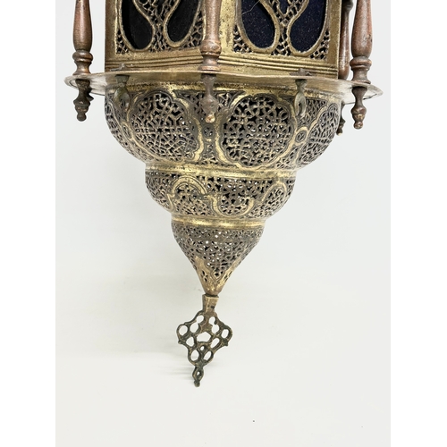 20 - A large early 20th century Moroccan brass ceiling lantern with stained glass panels. 80cm hanging.