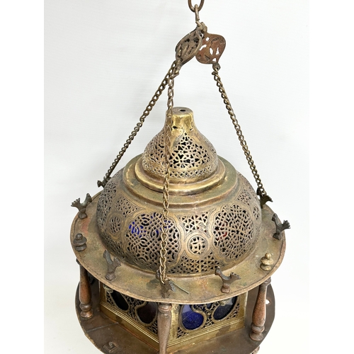 20 - A large early 20th century Moroccan brass ceiling lantern with stained glass panels. 80cm hanging.