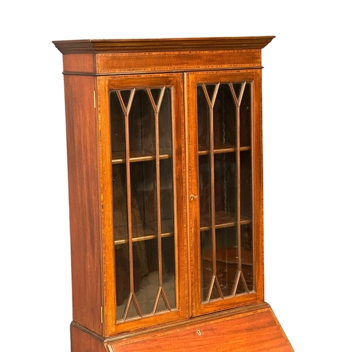 1005 - A late 19th century Sheraton Revival inlaid mahogany bureau bookcase. Circa 1890. 66x46x186cm. (5)