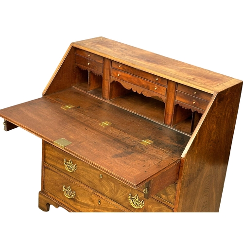 1012 - A George III mahogany writing bureau with original brass drop handles and 3 drawers on bracket feet.... 