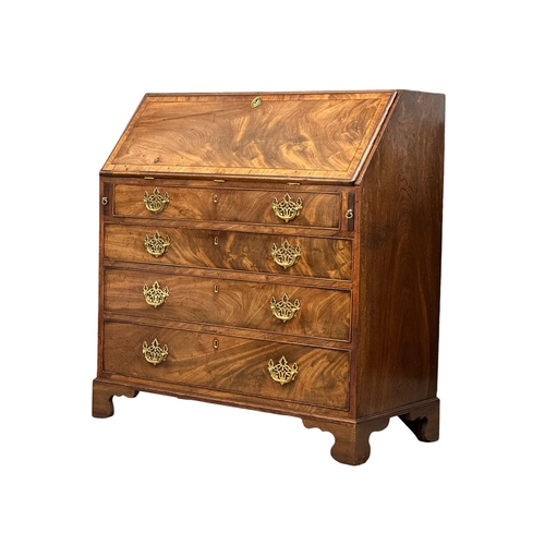 1012 - A George III mahogany writing bureau with original brass drop handles and 3 drawers on bracket feet.... 