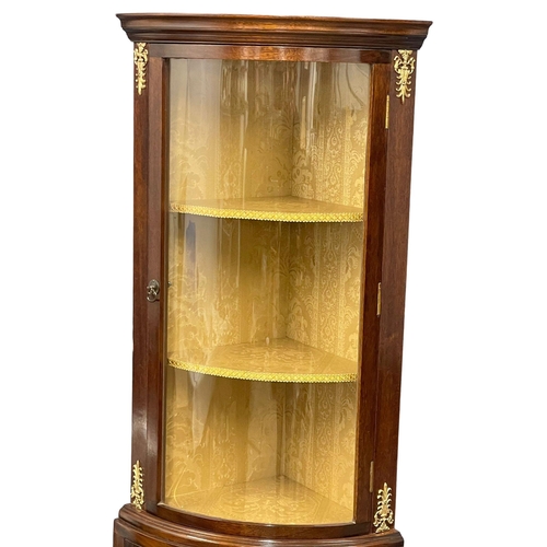 1015 - A mahogany bow front corner cabinet with brass ormolu mounts on splayed feet. 52x34x171.5cm (3)